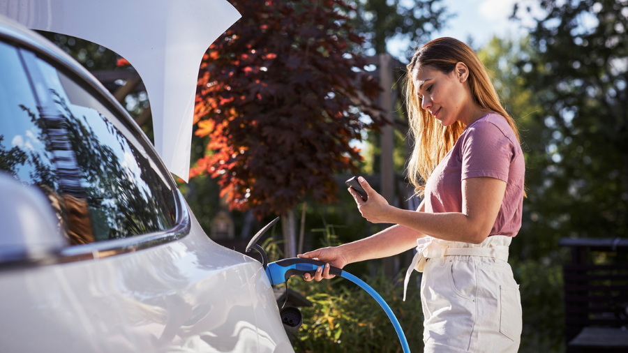 woman on the phone charging her car