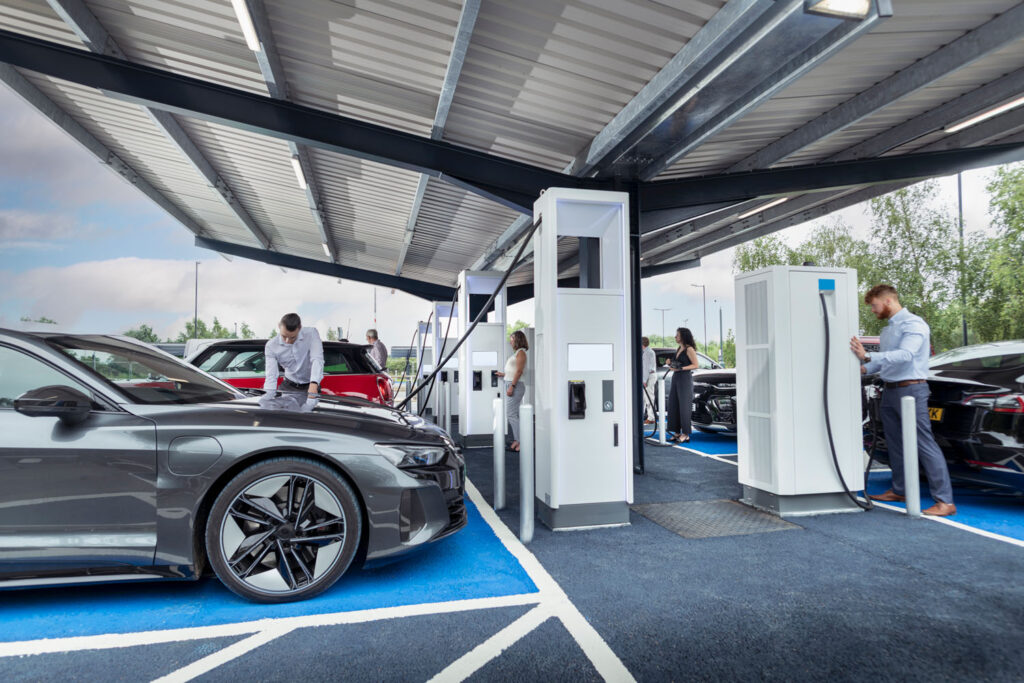 People charging their electric cars at charging station