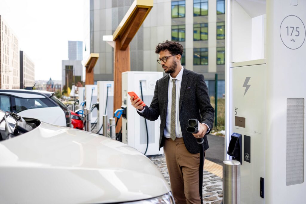 Man in smart wear charging his car